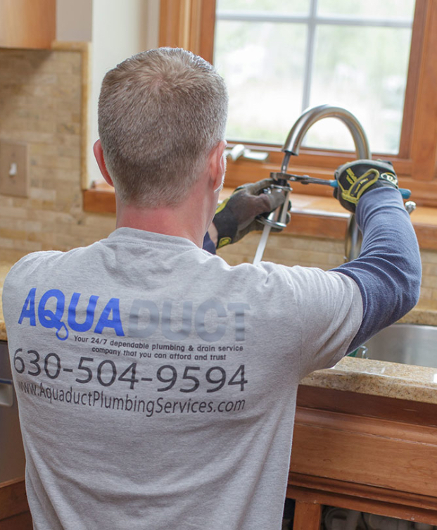 Pipe and Leak Repair in Oswego, IL - Plumber tightening kitchen faucet
