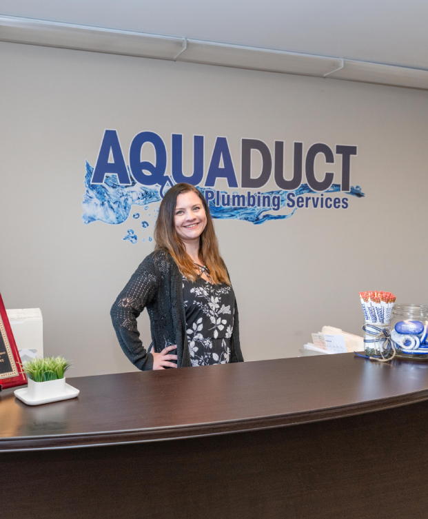 Staff posing with desk and company logo